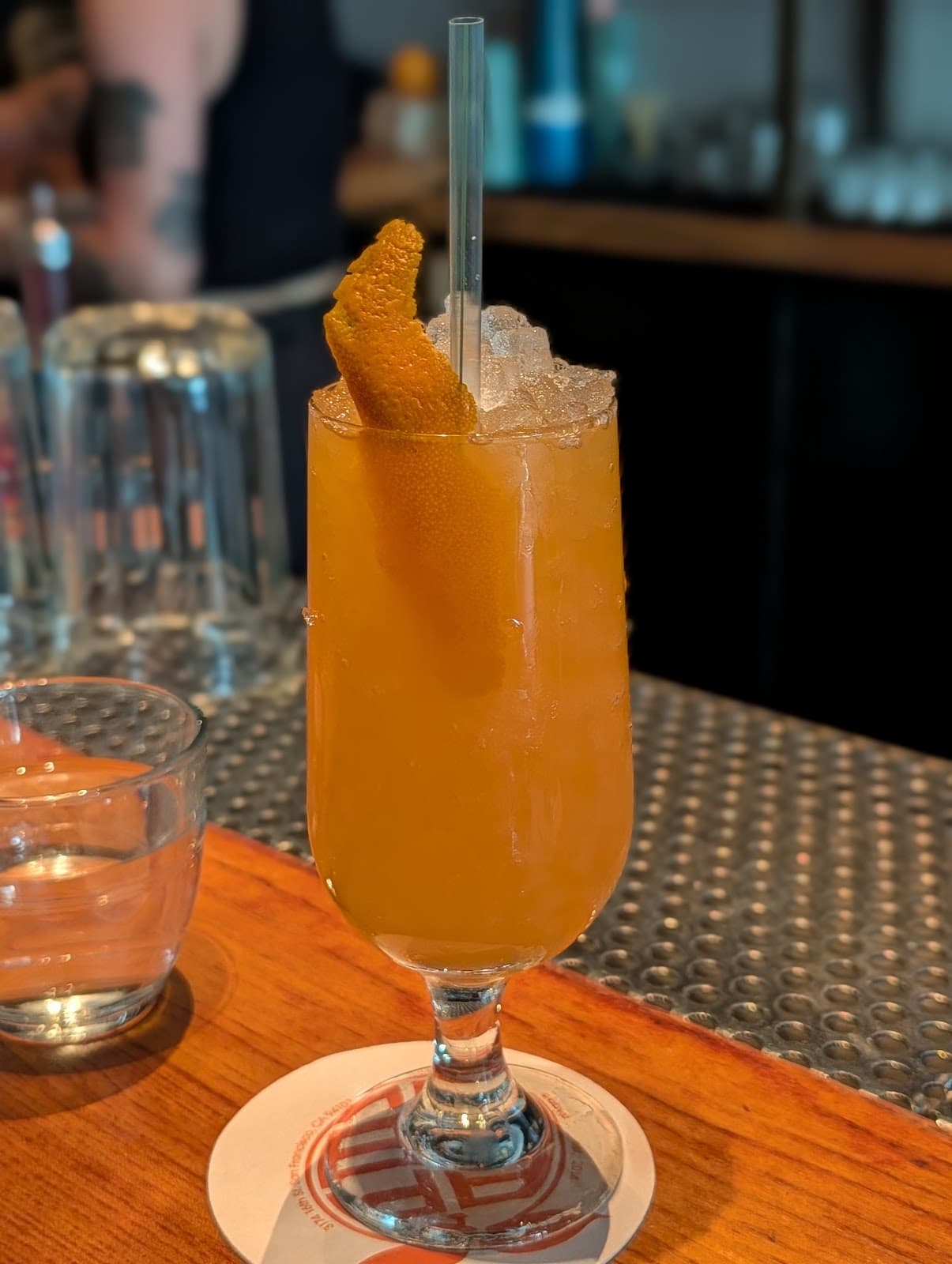 Orange cocktail with ice and garnish on a bar counter in San Francisco