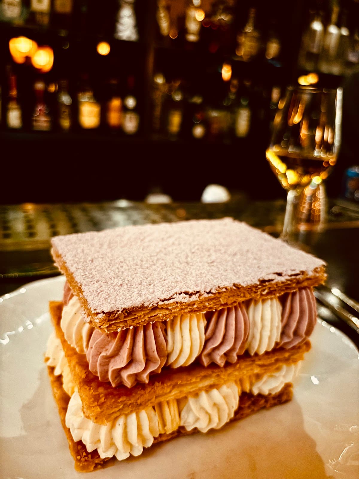 Close-up of a dessert on a bar counter with blurred bottles in the background in Toronto