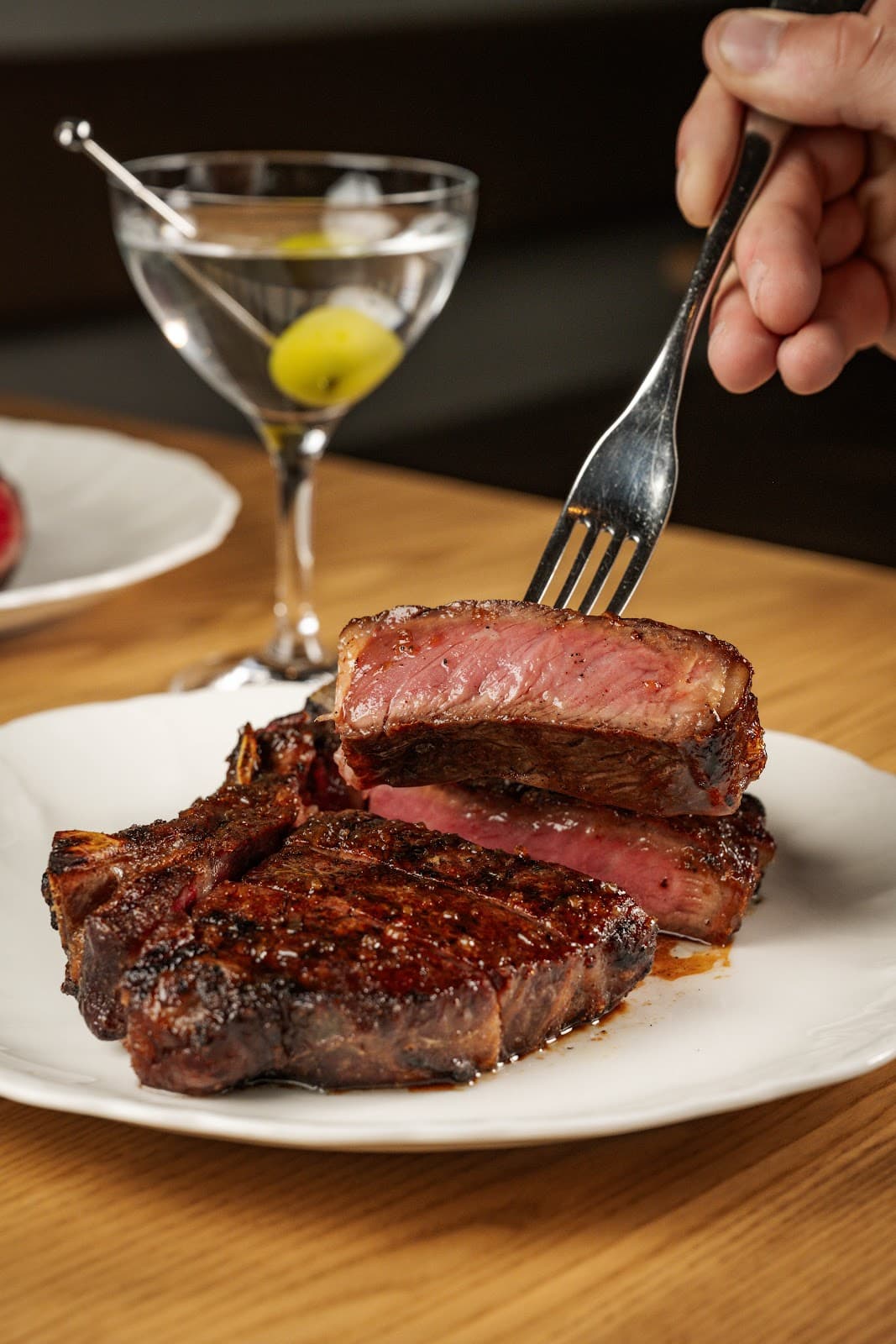 Close-up of martini with olives and steak on a plate in Toronto