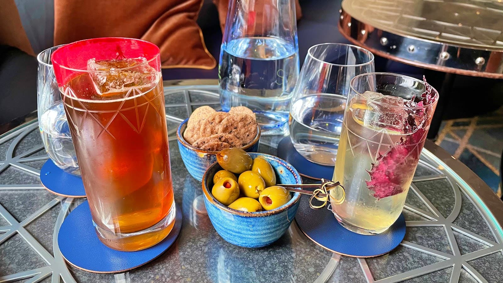 Close-up of cocktails with olives and snacks on a stylish table in London