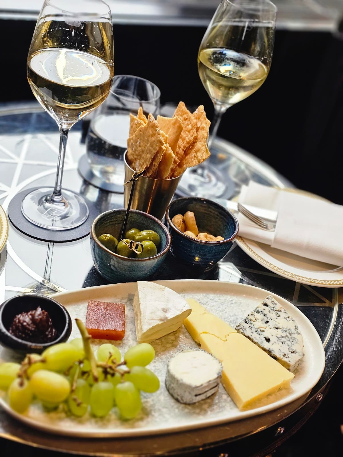 Elegant cheese and wine setting on a reflective table in London