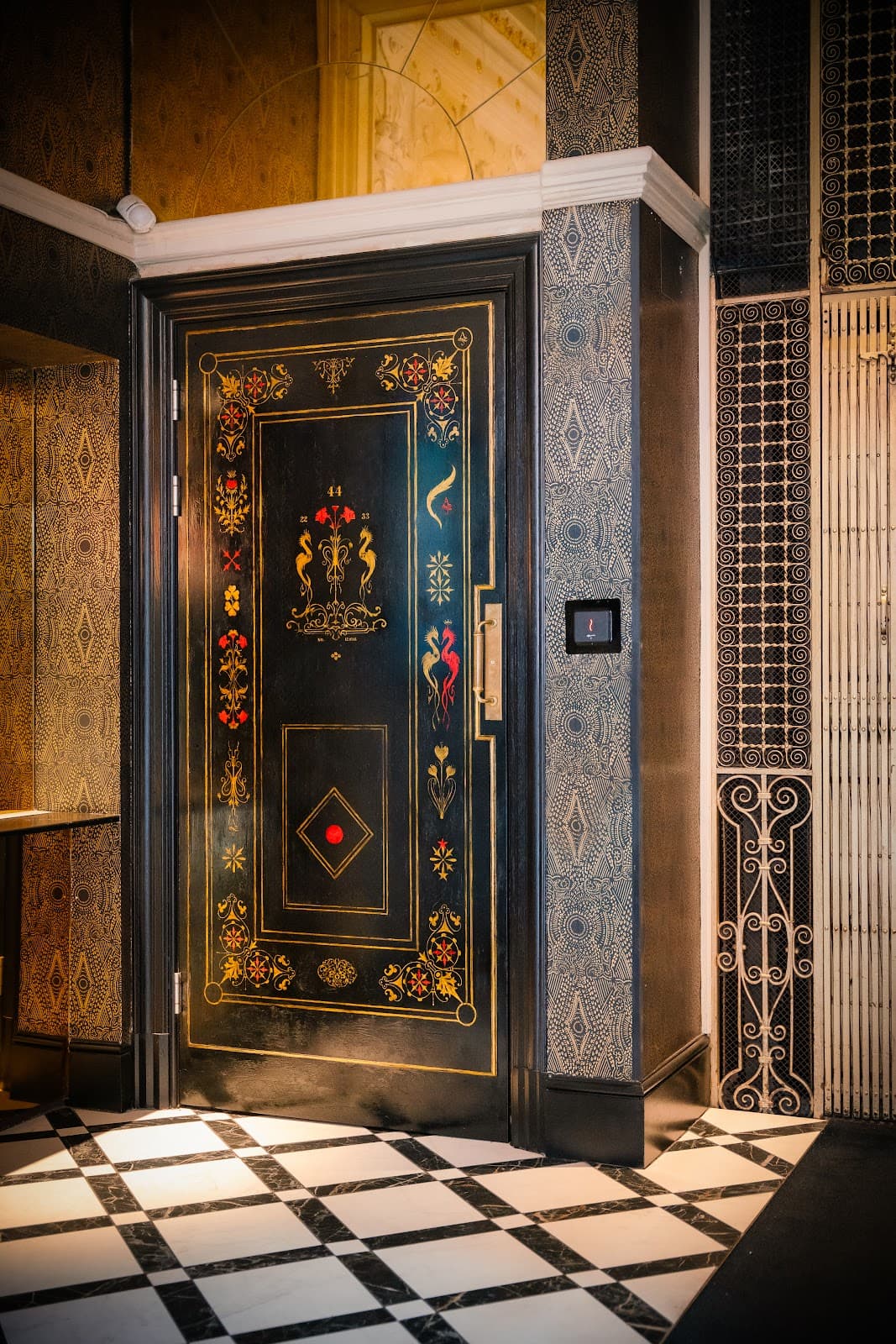 Ornate door with intricate patterns and dark wood finish in cocktail bar in London