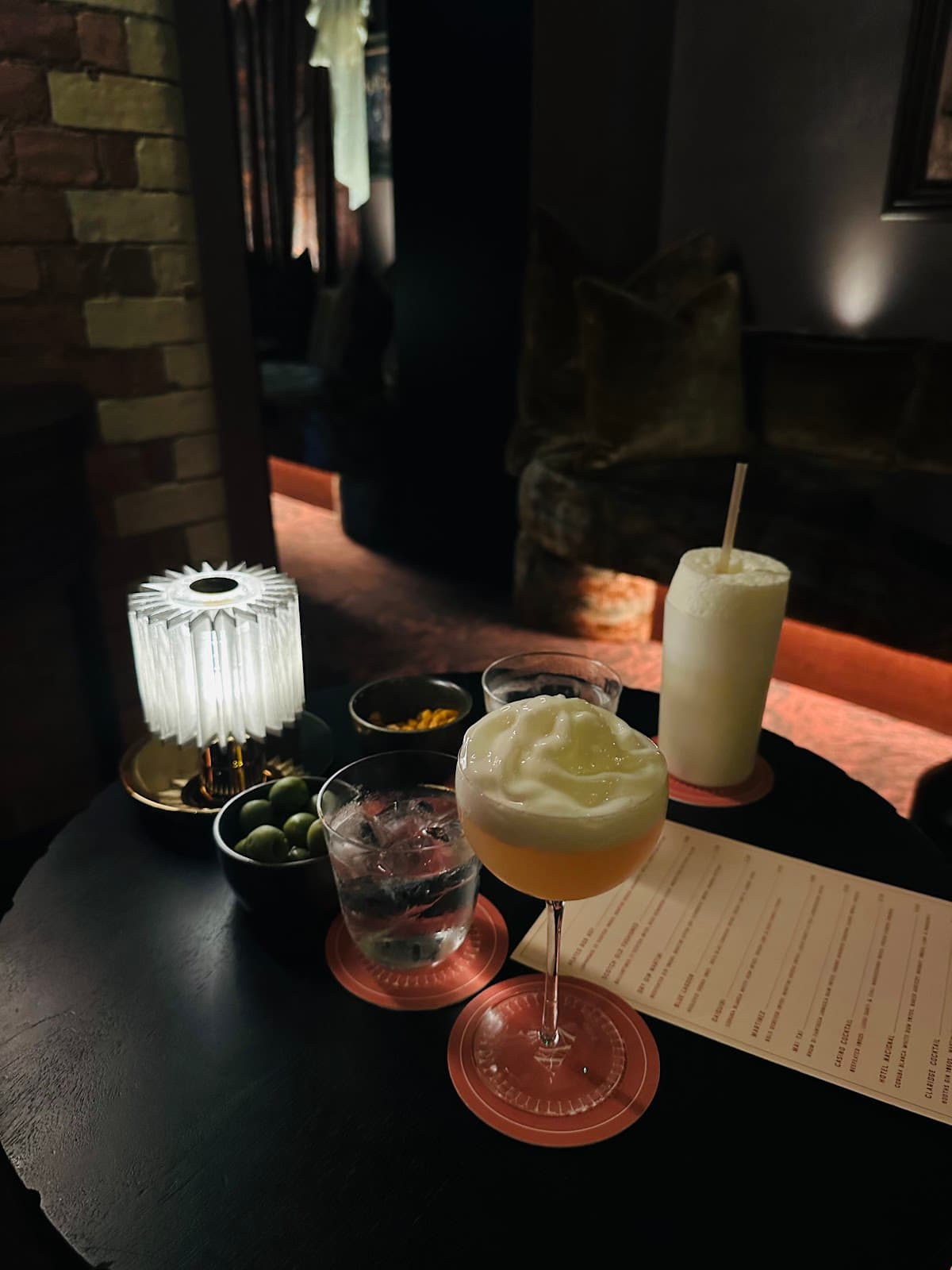 Intimate setting with cocktails on a dark table, soft lighting in London