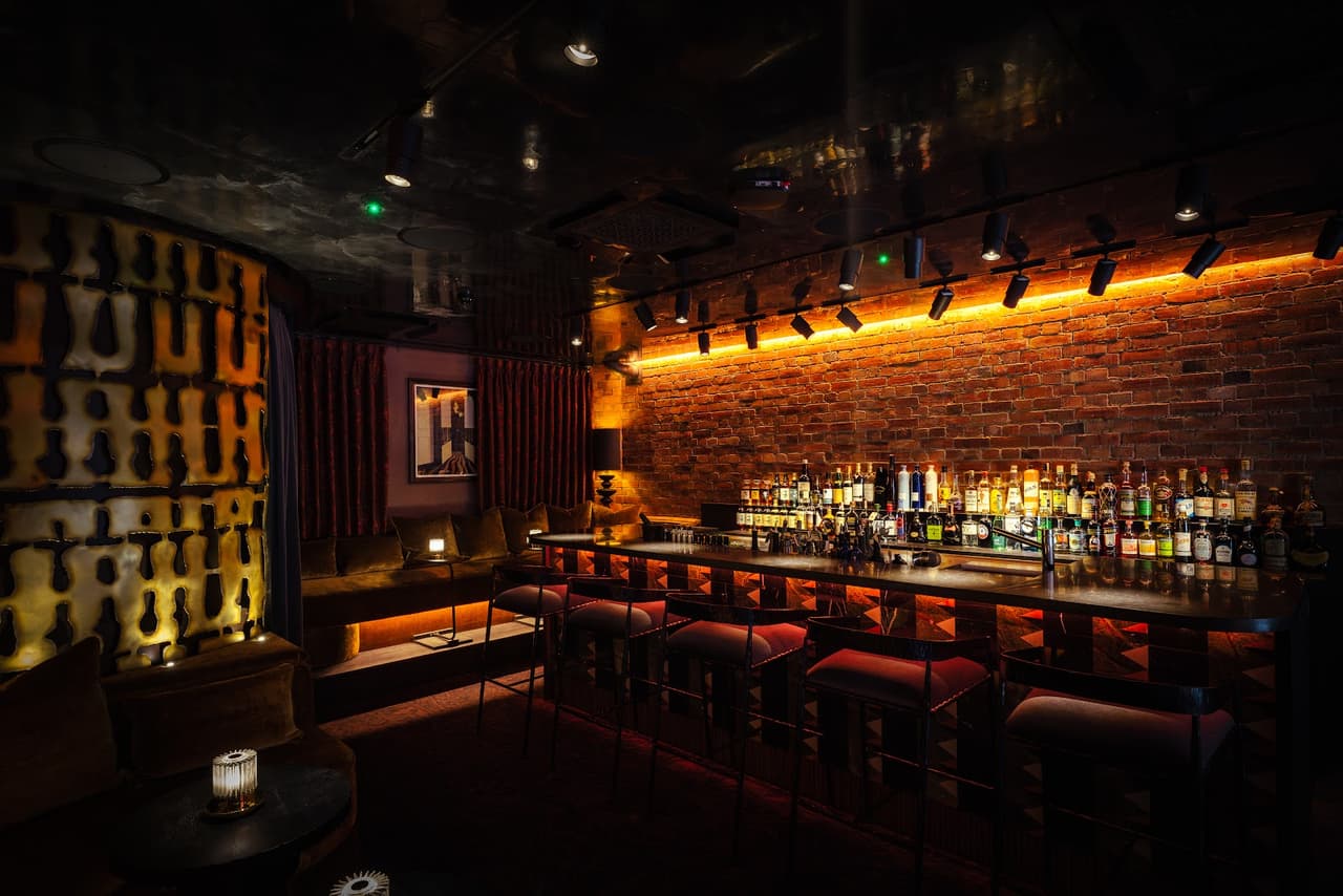 Sophisticated bar interior with dim lighting and brick walls