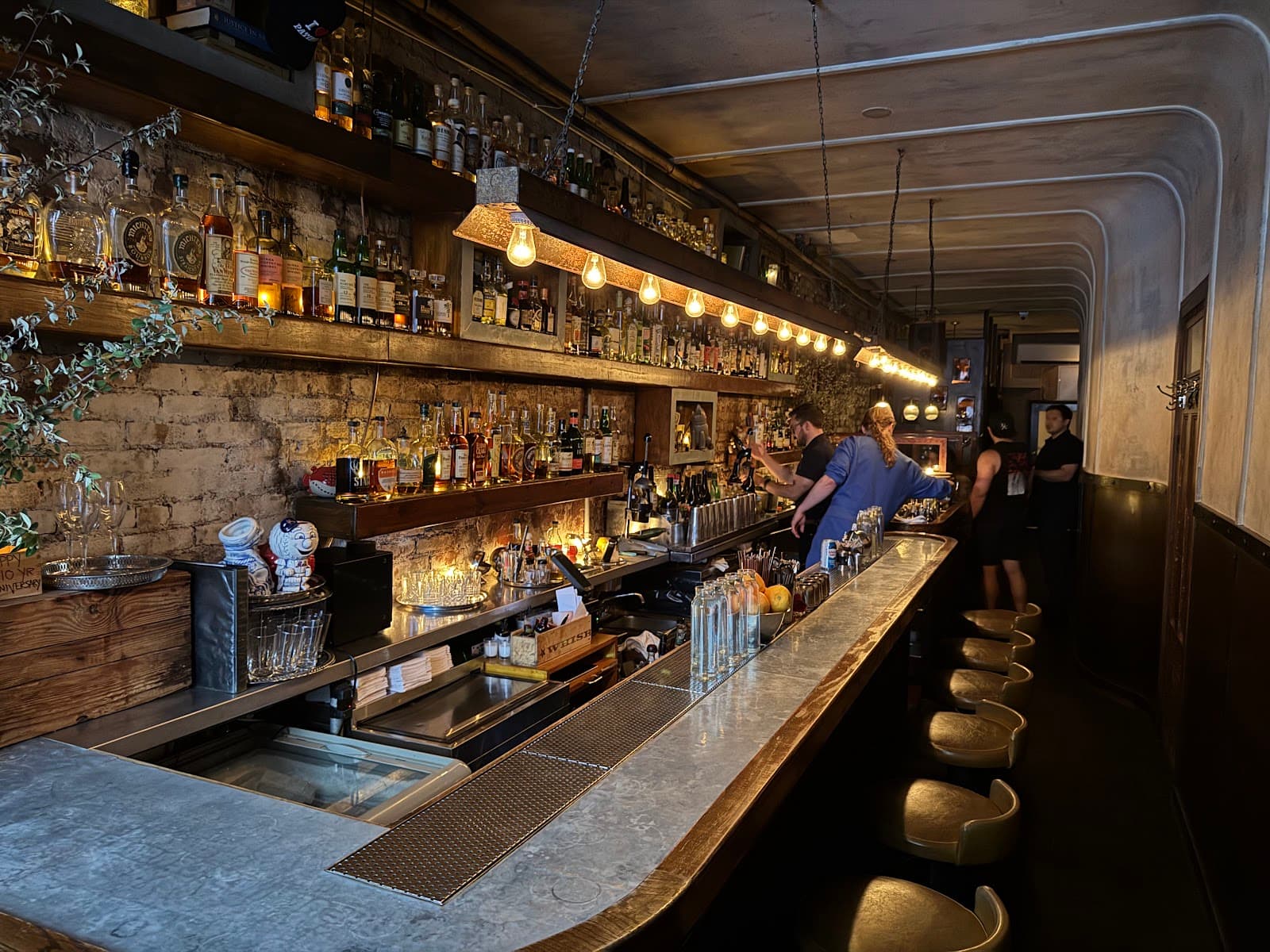 Stylish bar interior with exposed brick, bottles, and ambient lighting in New York