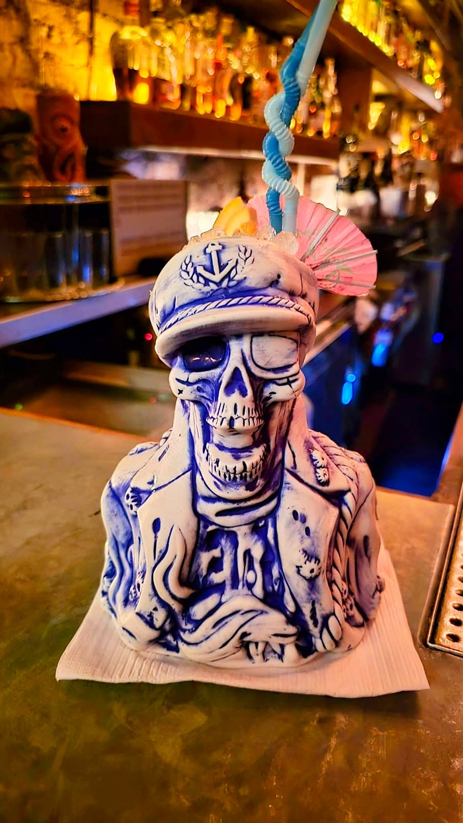 Ceramic skull-shaped cocktail mug with decorations on bar counter in New York