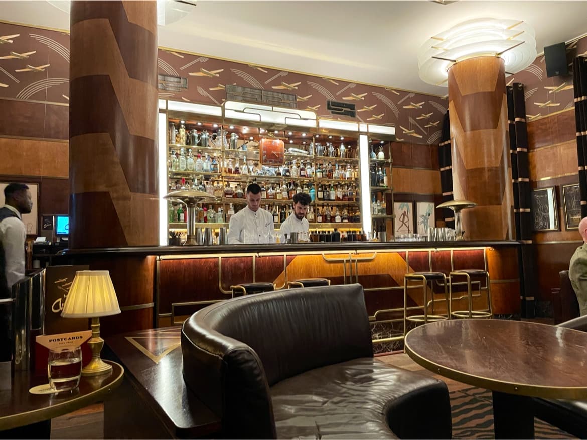 Elegant bar interior with two bartenders behind a stocked counter in London