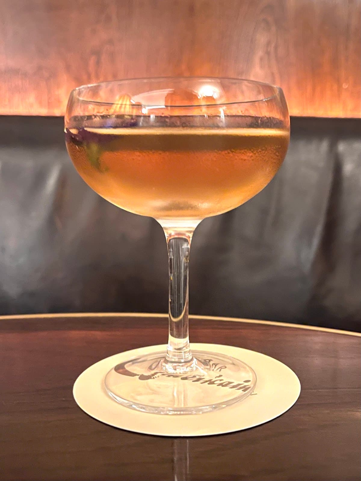 Elegant cocktail in a coupe glass on a wooden table in London