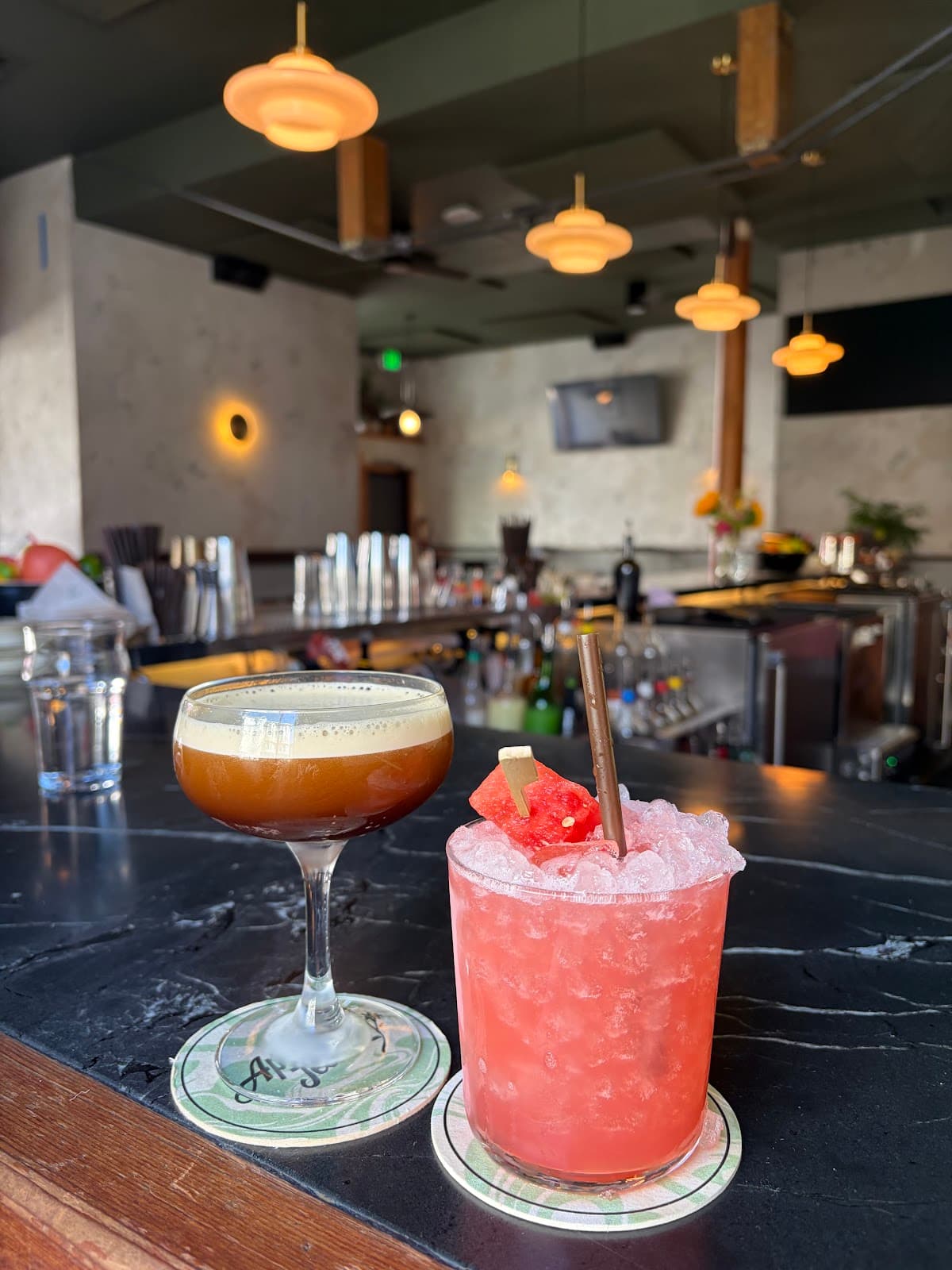Close-up of two cocktails on a bar counter with warm lighting in San Francisco