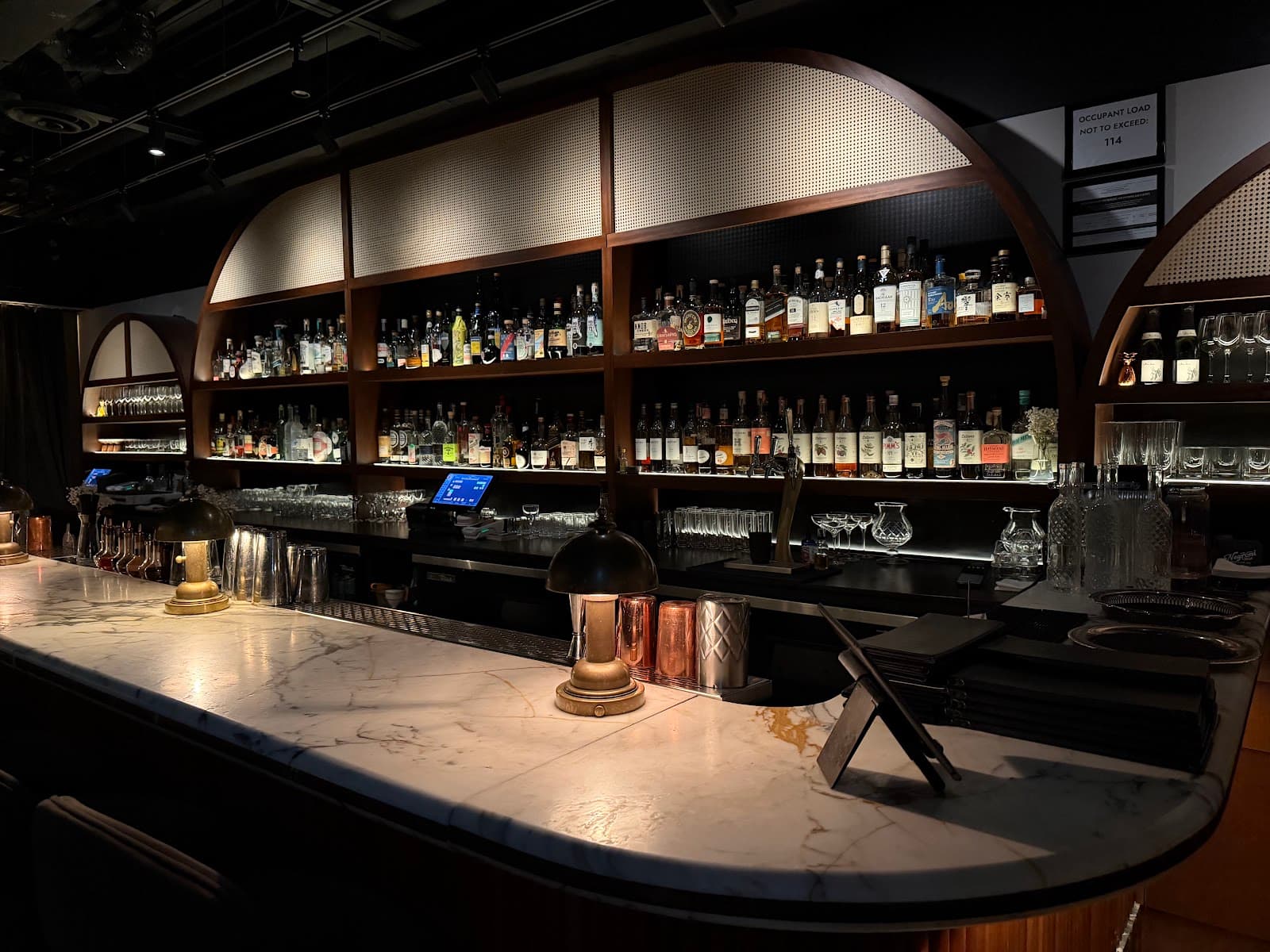 Elegant bar with marble countertop and shelves of liquor bottles