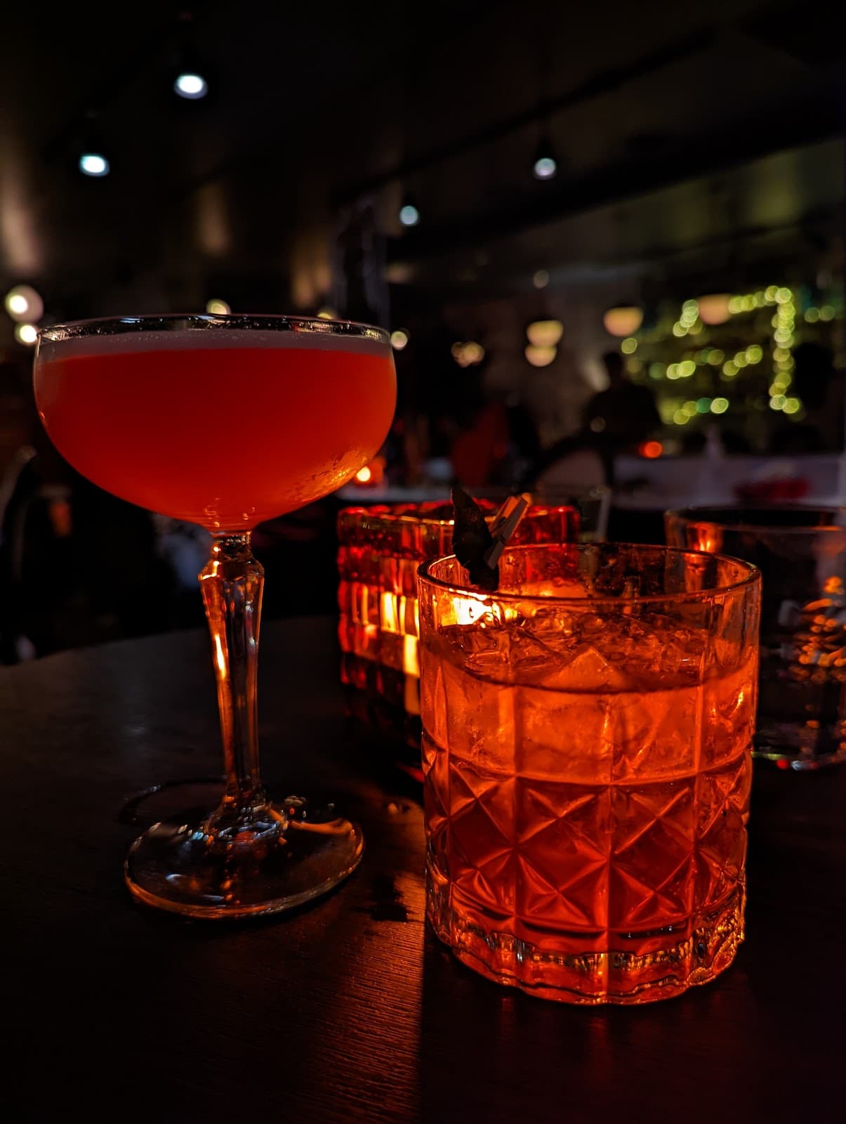 Close-up of two cocktails on a dimly lit table in Toronto