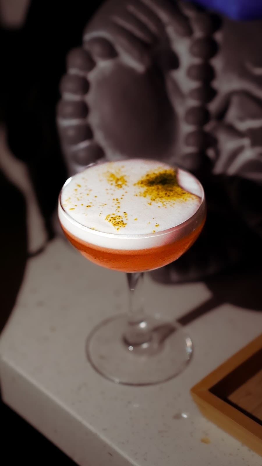 Elegant cocktail with frothy top garnished on a table in Toronto