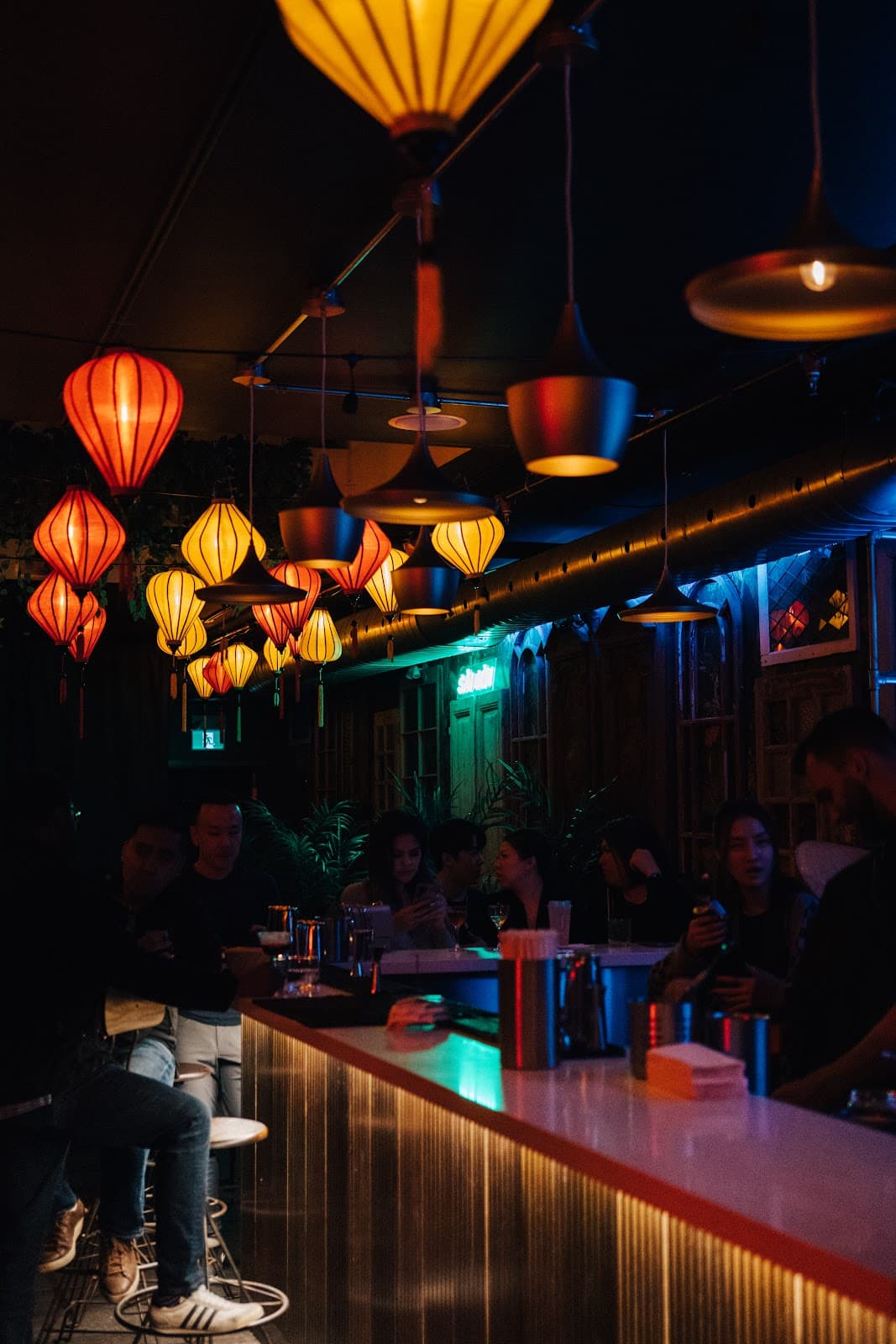 Atmospheric bar interior with hanging lanterns and seated patrons in Toronto