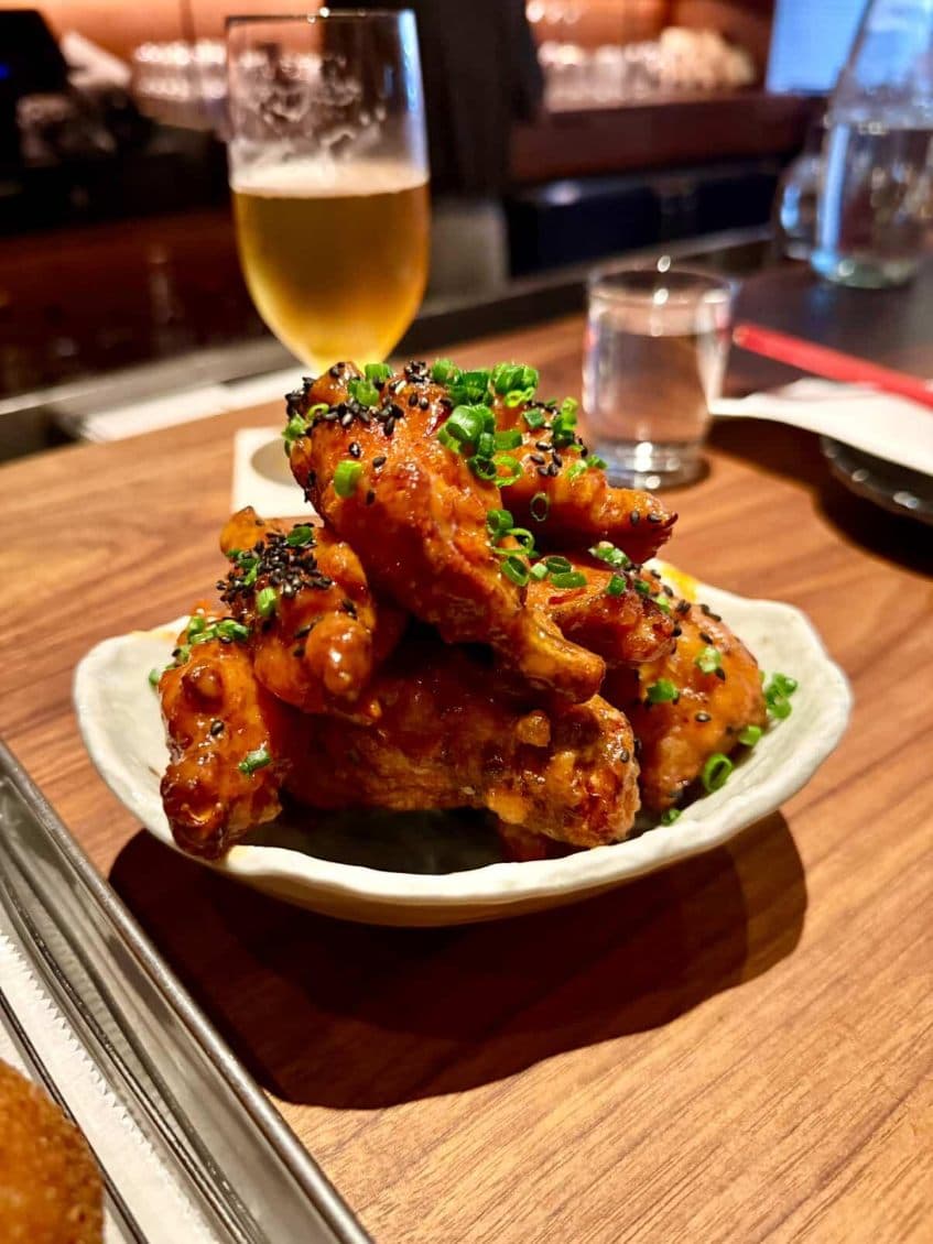 Bar counter with chicken wings plate and a glass of beer in New York