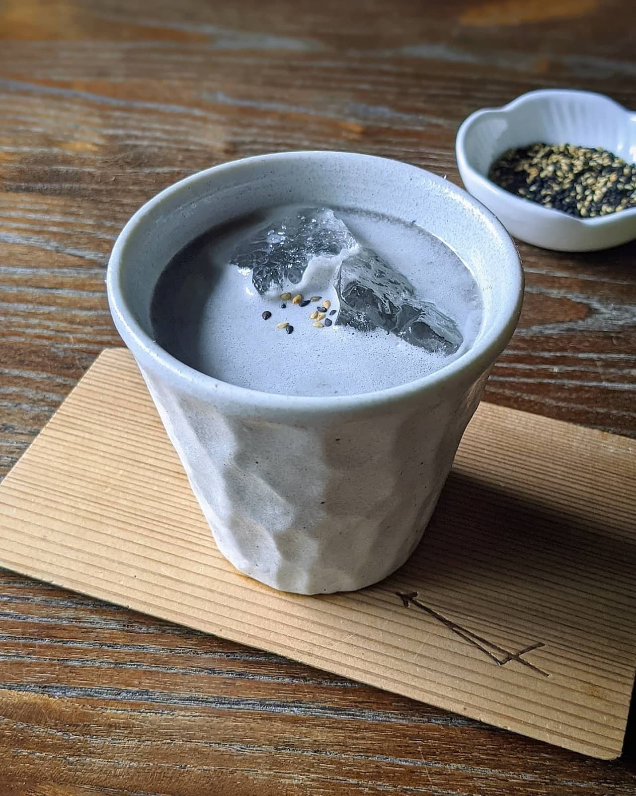 Ceramic cup with a cocktail and ice on a wooden table in New York