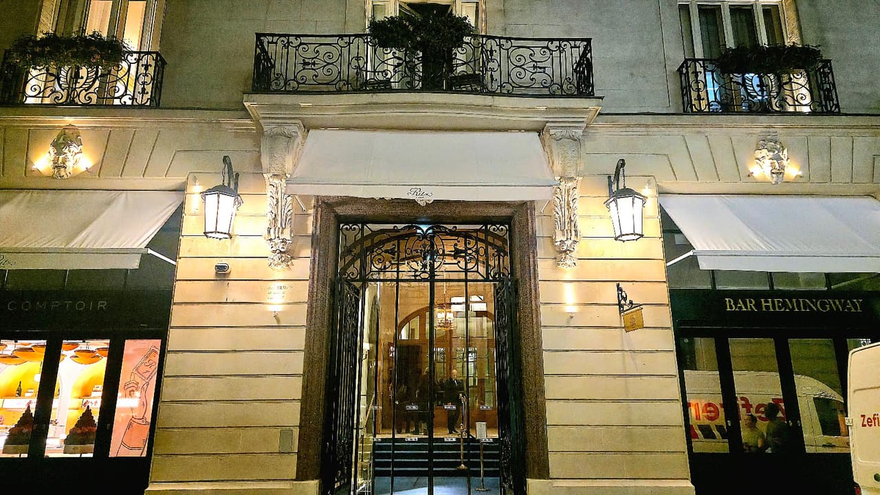 Exterior of Bar Hemingway at night with ornate lighting and entrance. in Paris
