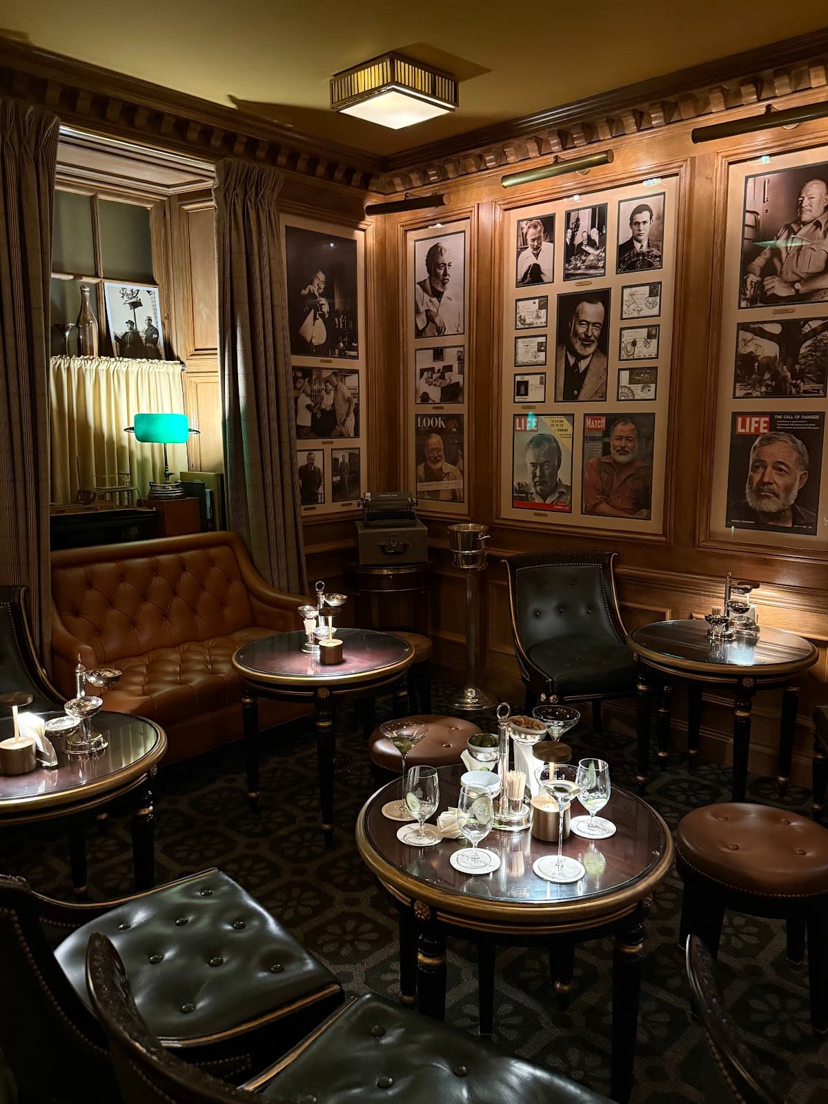 Cozy bar interior with leather seating and wall of vintage photos. in Paris