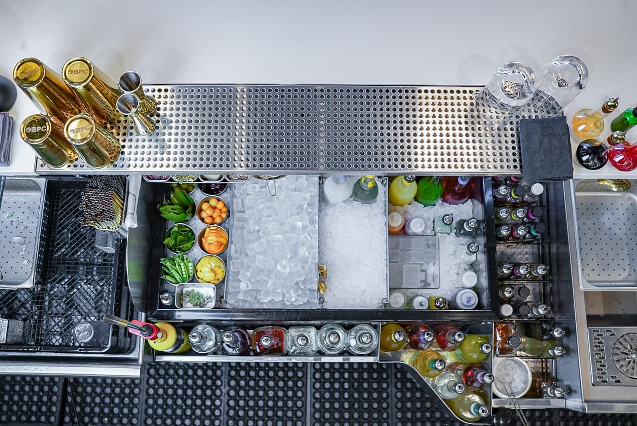 Overhead view of a well-stocked bar with mixers and fresh ingredients
