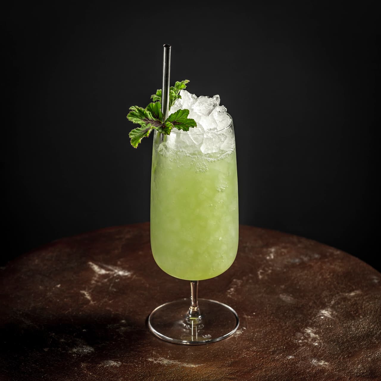 Green cocktail with crushed ice and mint garnish on a dark surface in San Francisco