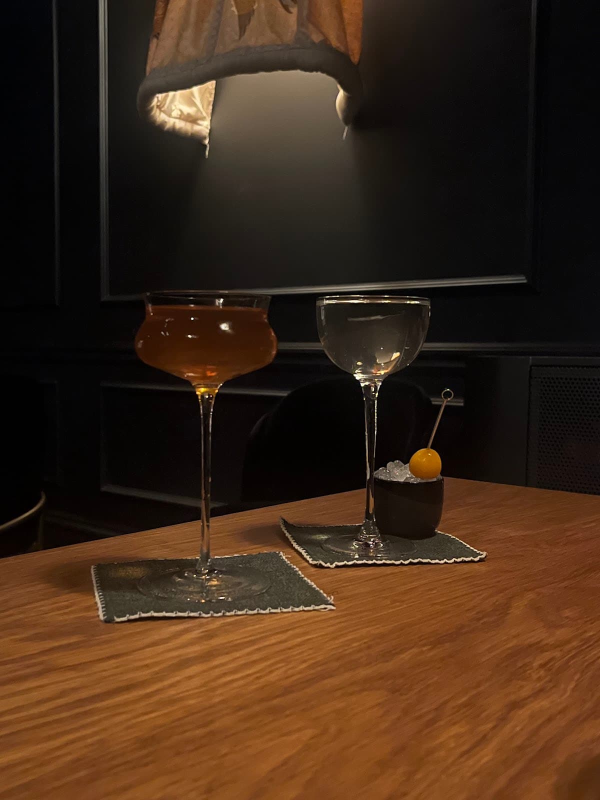 Two cocktails on a wooden table under dim lighting in San Francisco