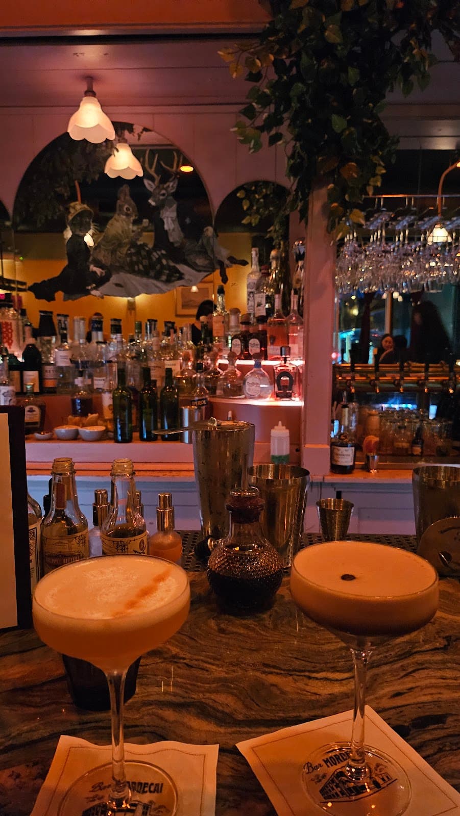 Bar countertop with cocktails, bottles, and hanging glasses in Toronto