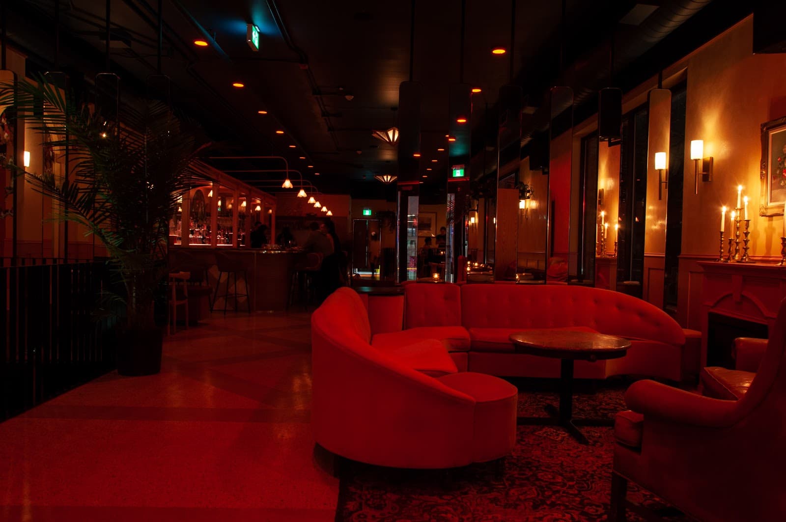 Sophisticated bar interior with red couches and elegant lighting