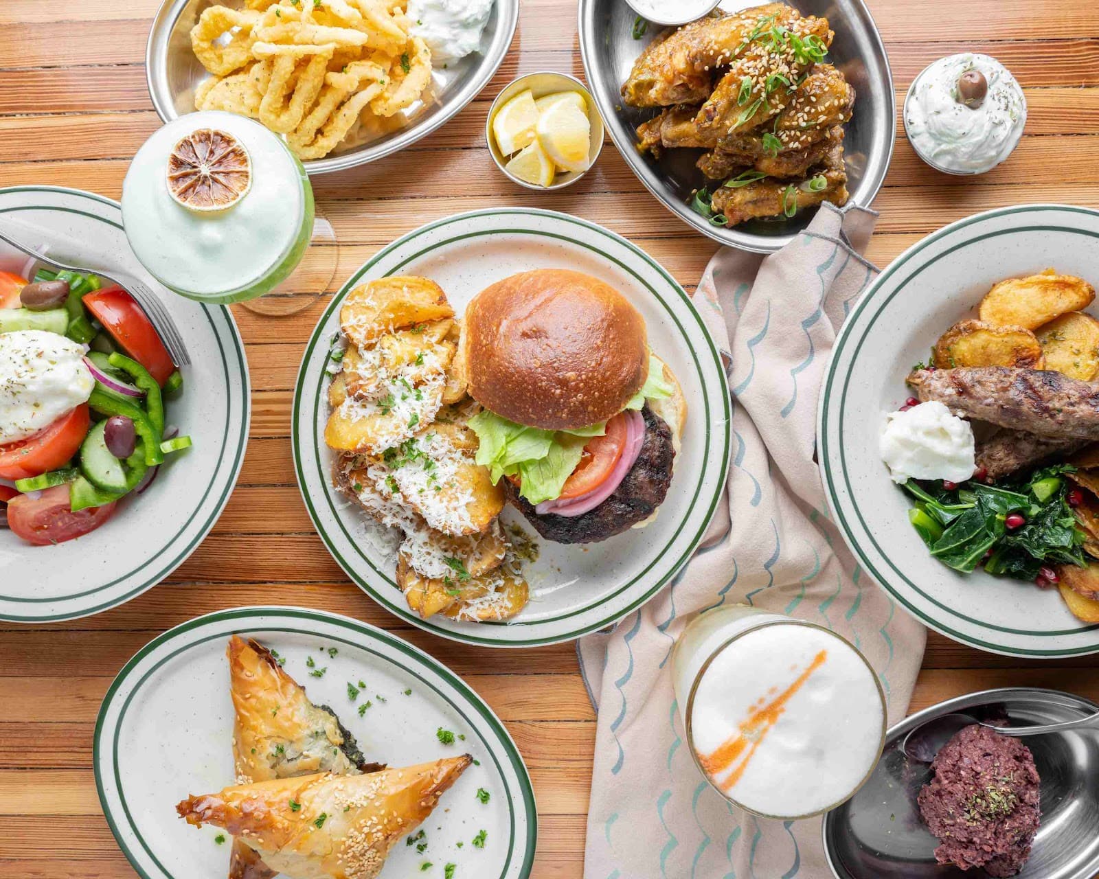Top view of assorted dishes and cocktails on a wooden table in Toronto