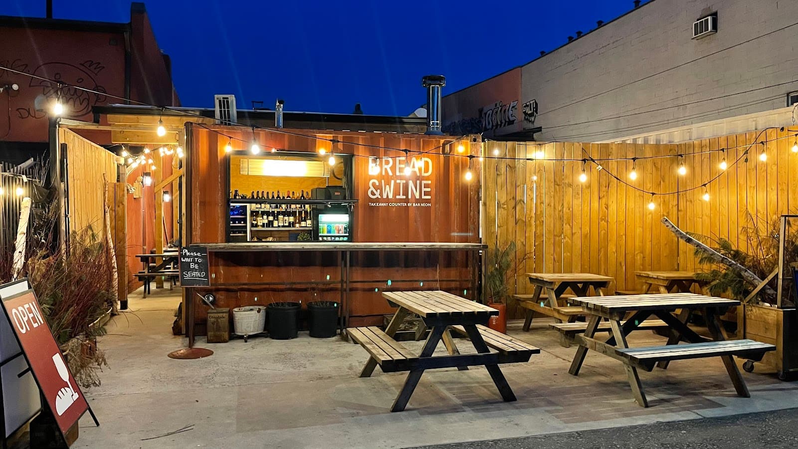 Outdoor seating area with picnic tables at Bread & Wine in Toronto