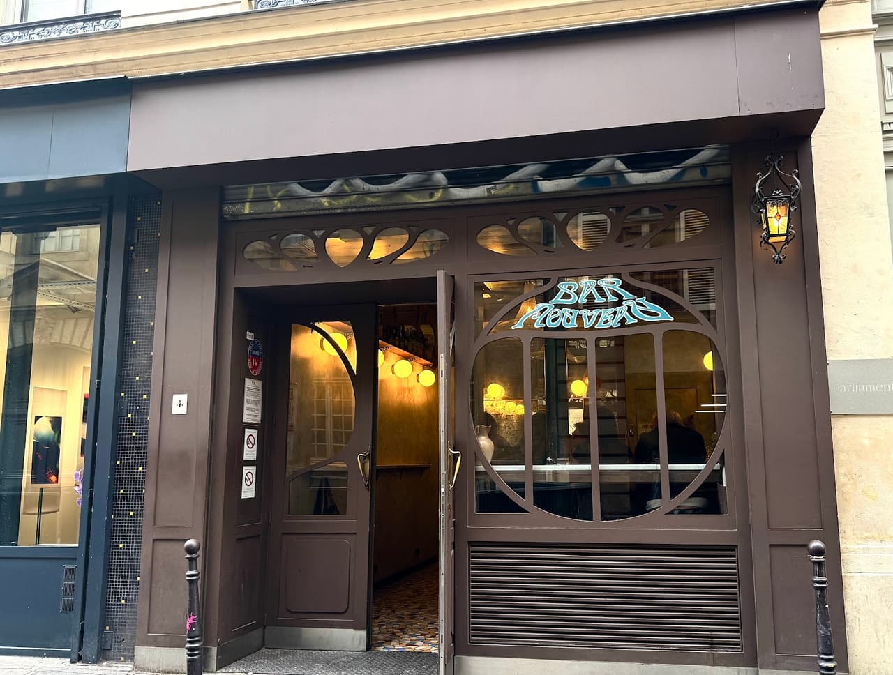 Exterior of Bar Nouveau with art deco design elements and glass door in Paris