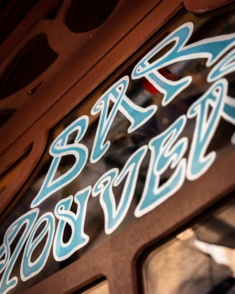Close-up of bar entrance with stylized lettering on glass in Paris