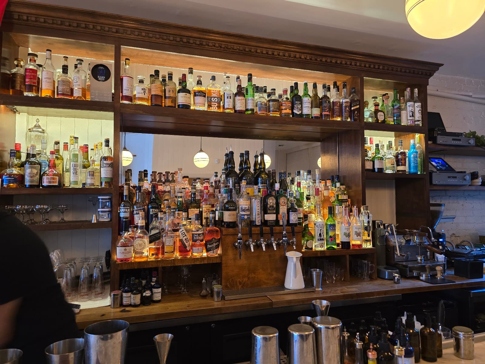Well-stocked bar shelf with various liquor bottles and bar tools in Toronto