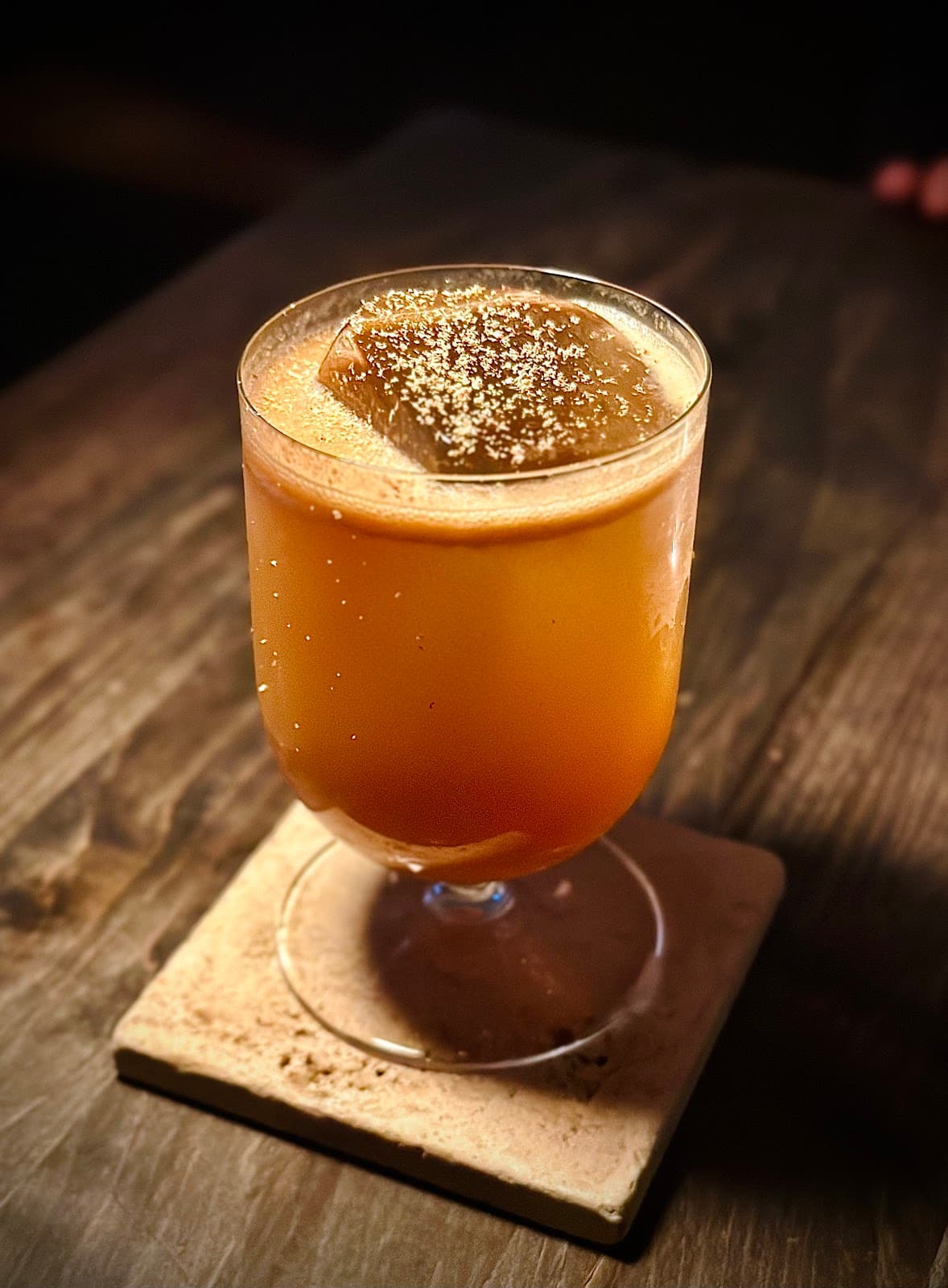 Artisan cocktail on a wooden table in warm lighting in Toronto