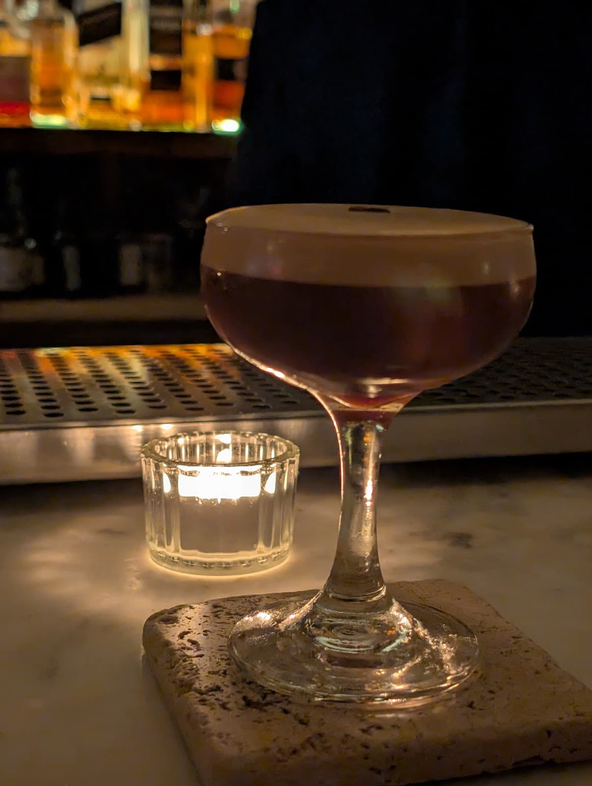 Close-up of cocktail on marble bar with candle light in Toronto