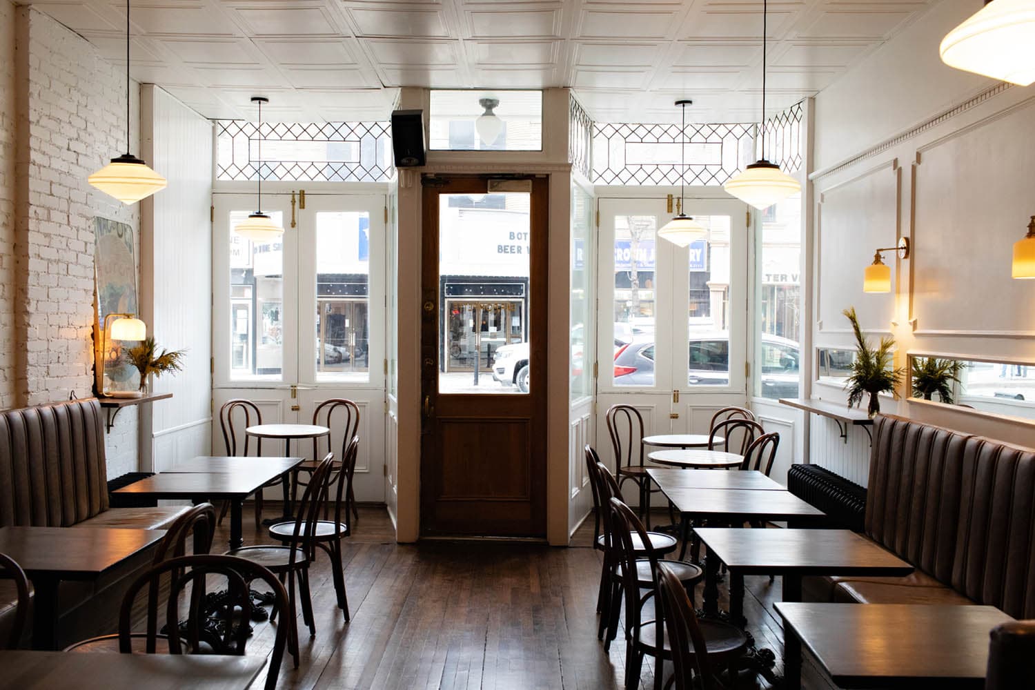 Bright interior of a bar with large windows and wooden furniture