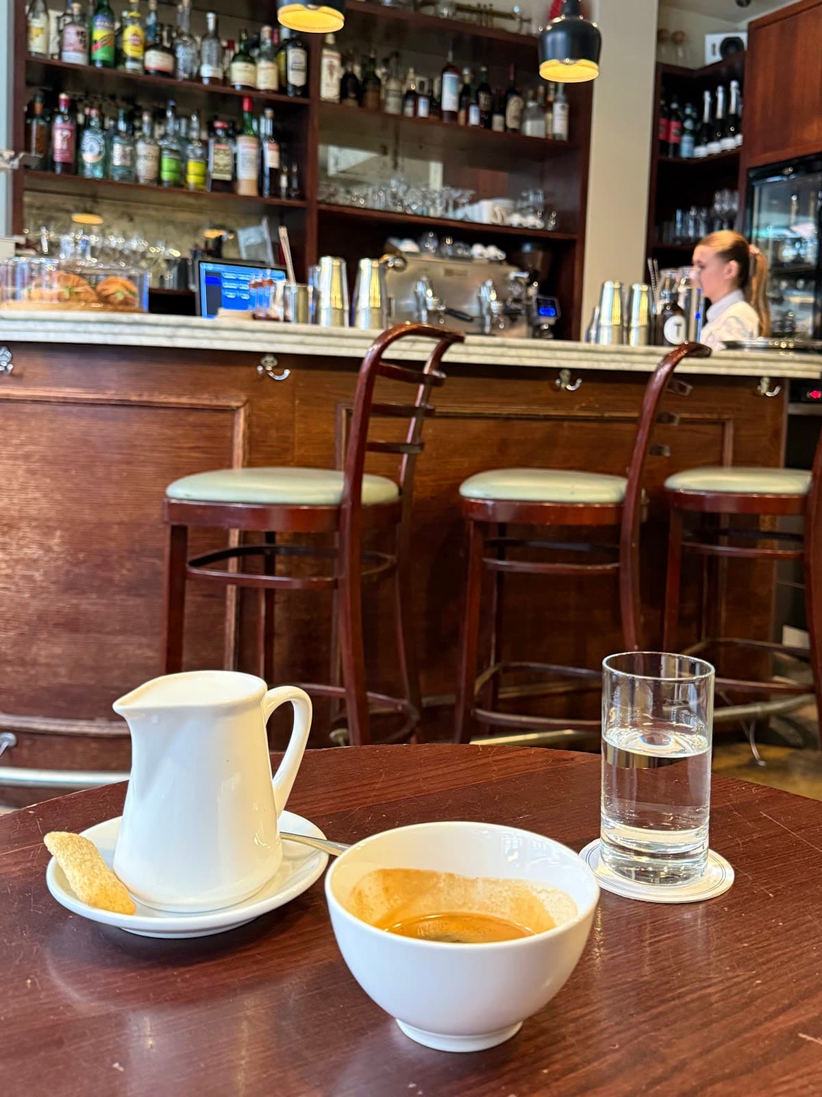 Close-up of a bar with a coffee setup and bottles in the background in London