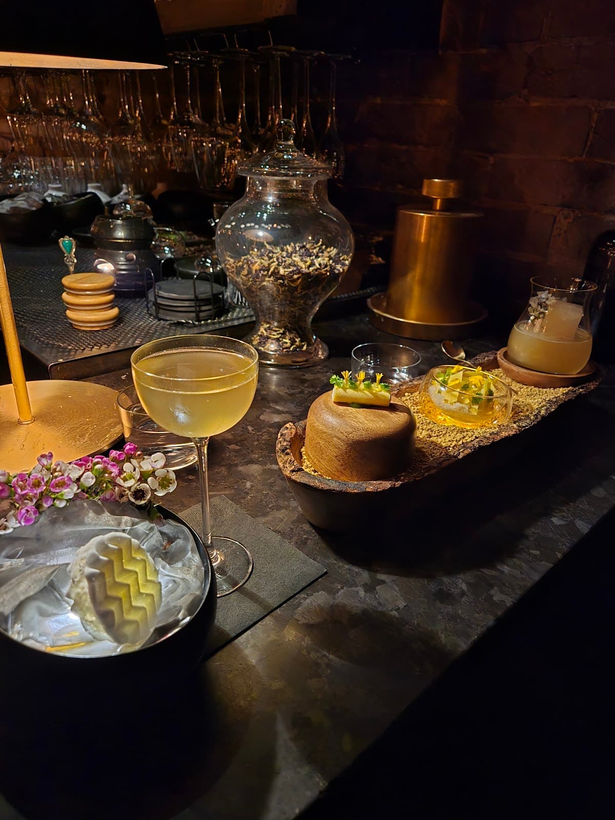 Elegant cocktail setup with drink and decor on a dimly lit bar counter in Toronto