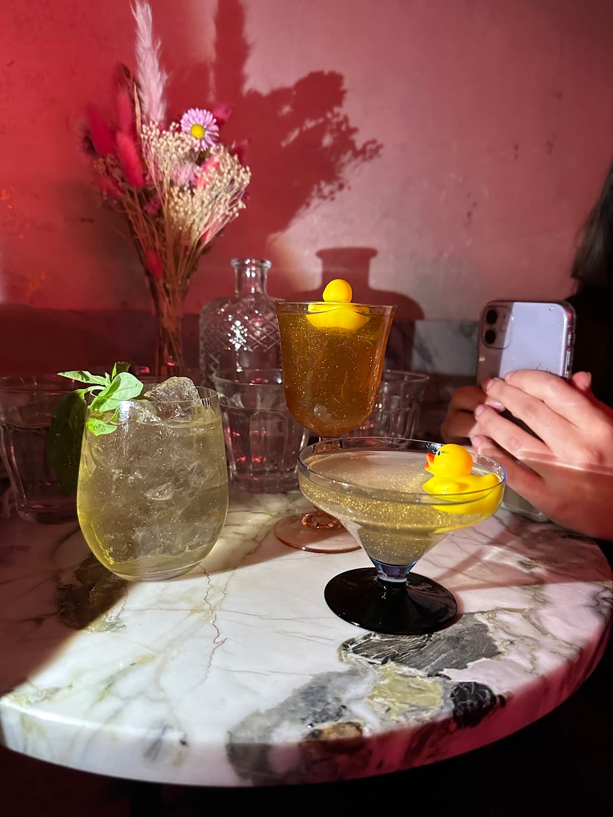 Artistic cocktail presentation on marble table with decorative flowers in Paris