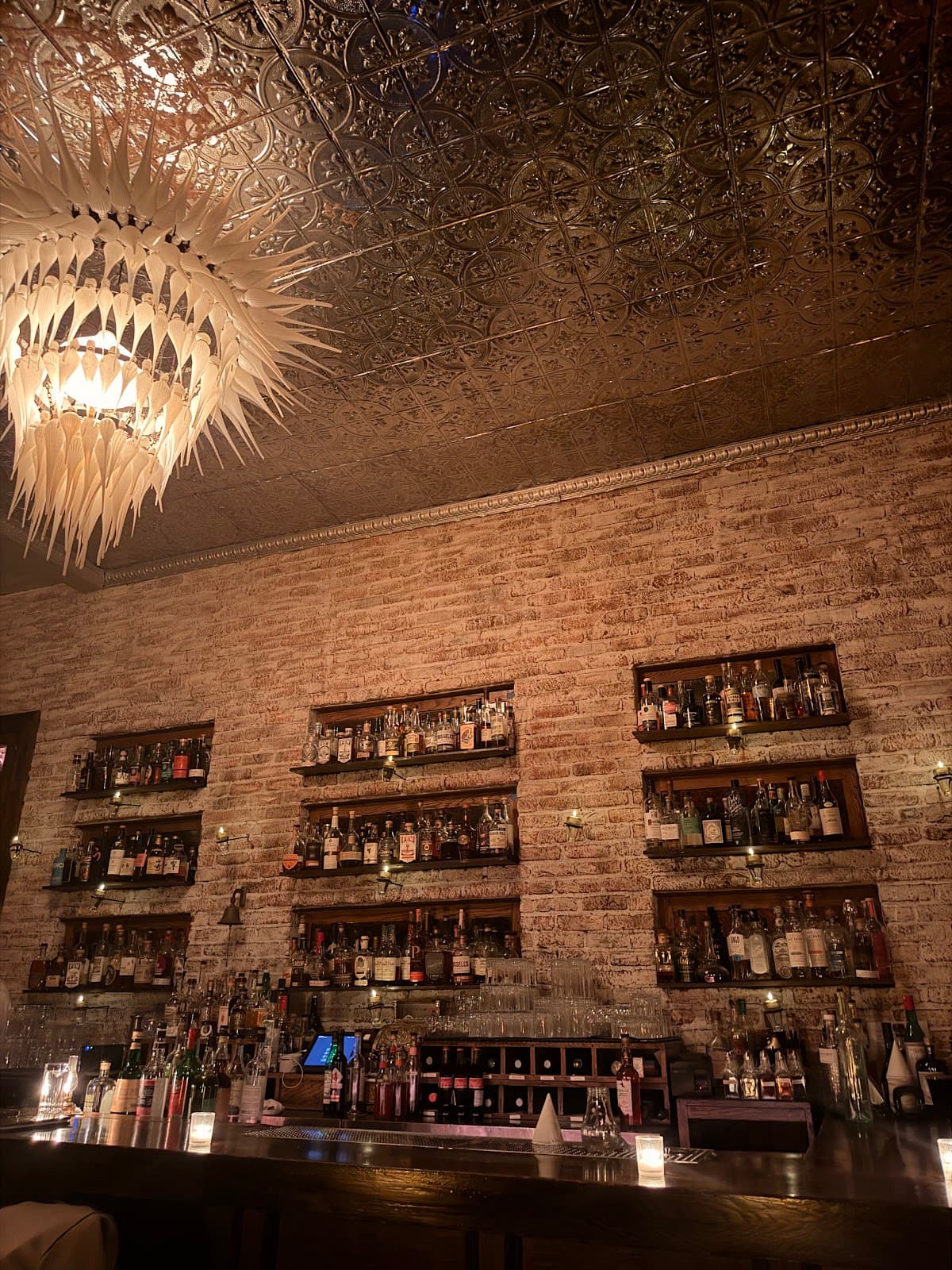 Cozy bar with exposed brick walls and an intricate chandelier in San Francisco