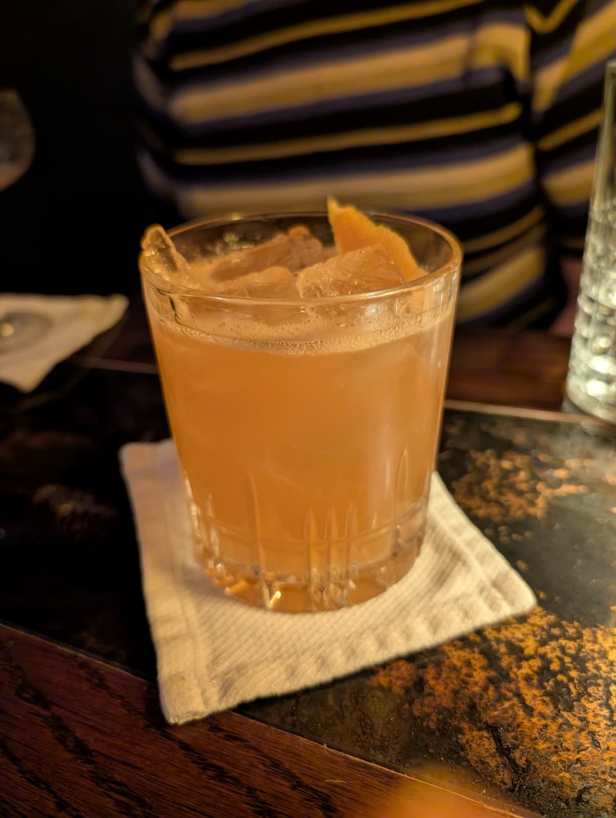 Close-up of a cocktail glass with an orange peel garnish on a bar. in San Francisco