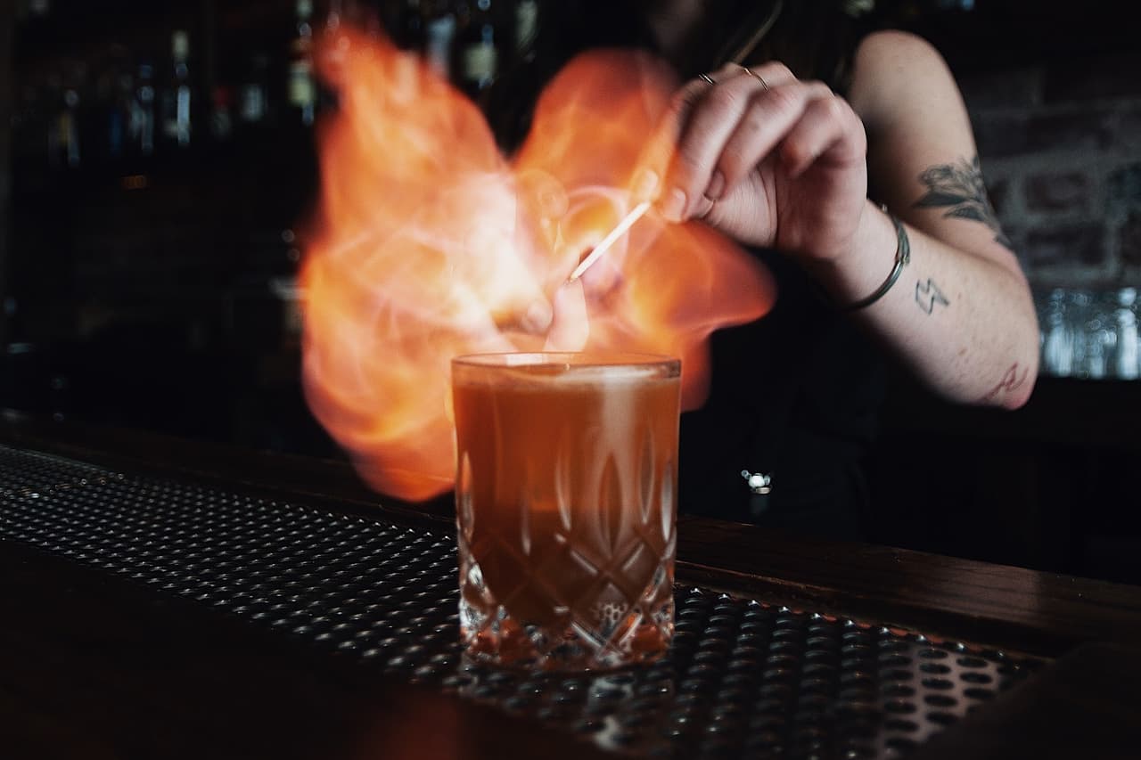 Bartender igniting a cocktail on a bar counter in San Francisco