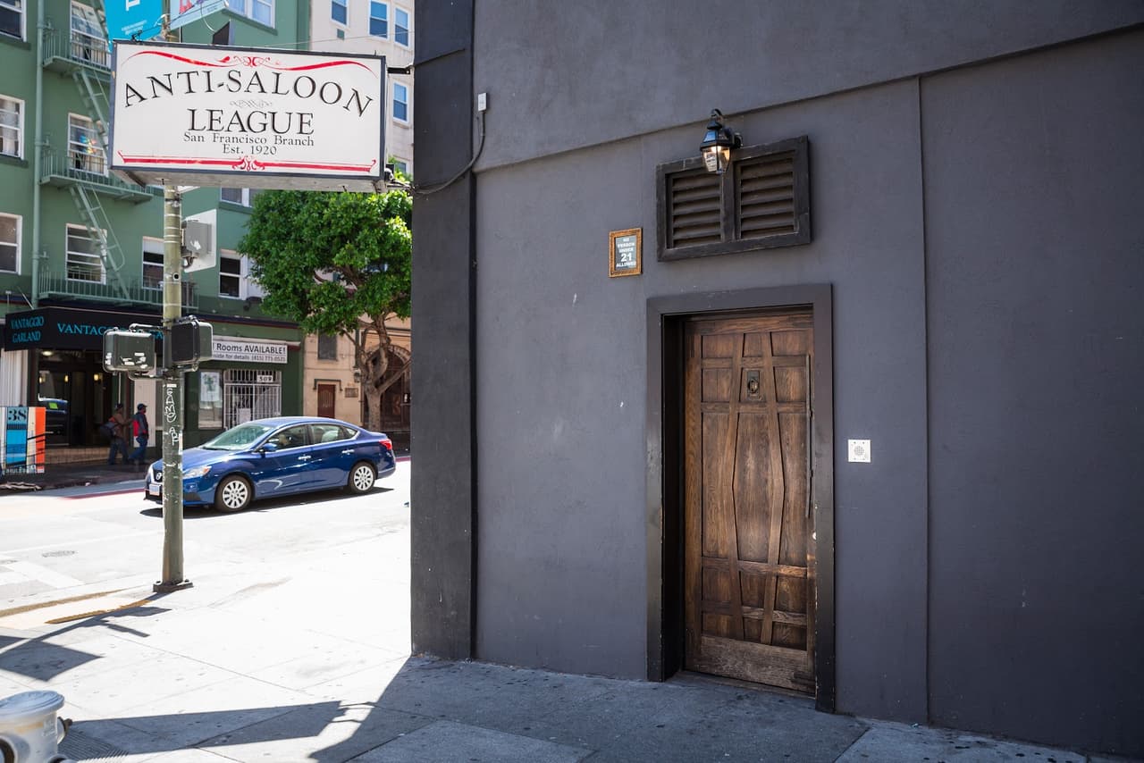 Entrance to Anti-Saloon League bar with wooden door and wall signage
