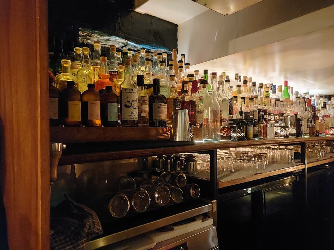 Dimly lit bar with various liquor bottles on shelves