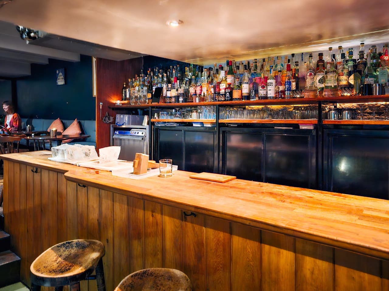 Cozy bar with wooden counter and bottles on shelves in Edinburgh