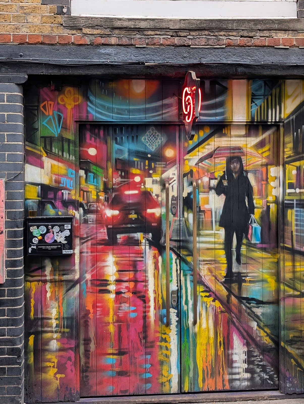 Colorful mural on a building entrance with neon lights and urban scene in London