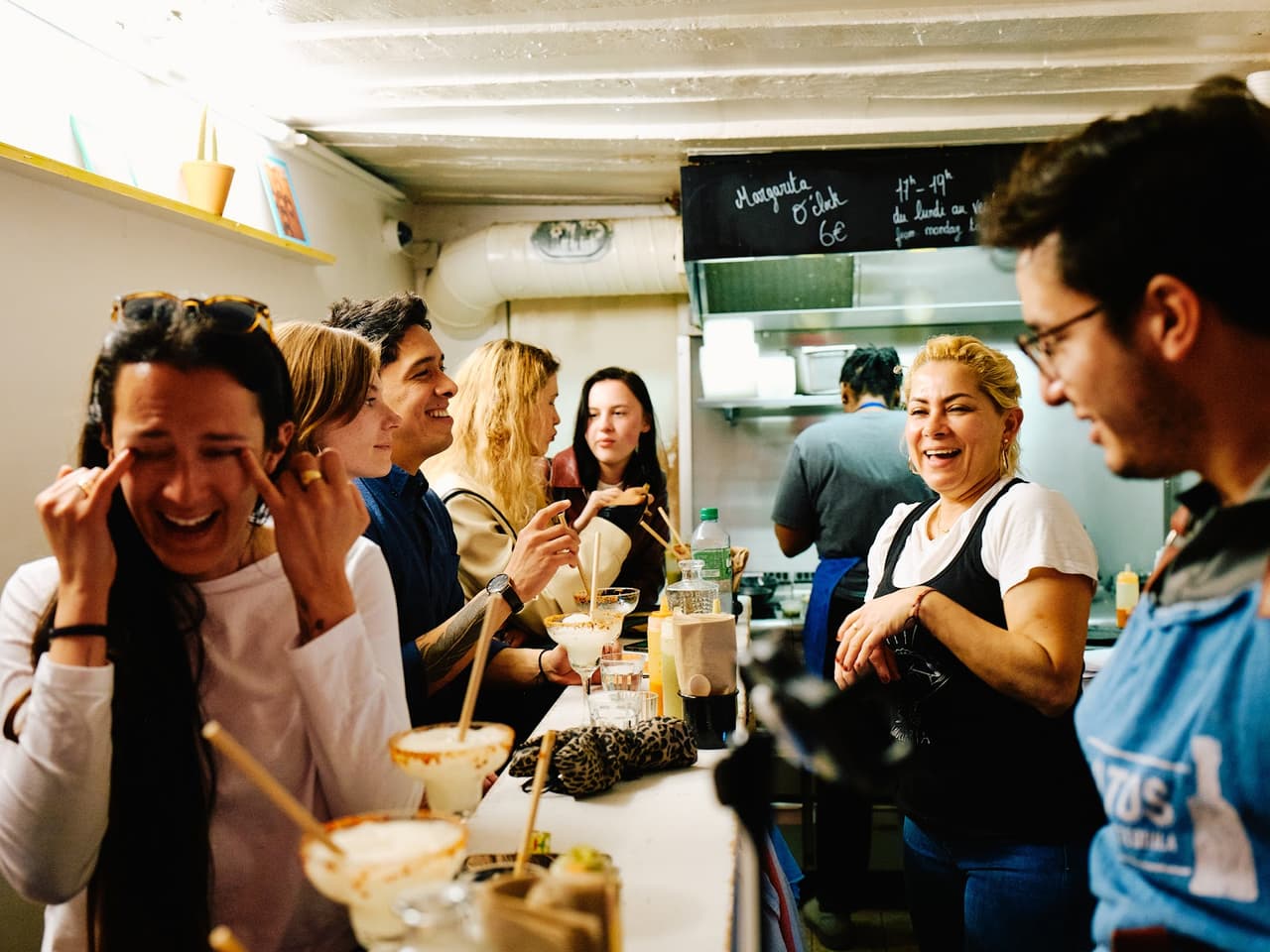 Lively bar scene with people enjoying margaritas in Paris