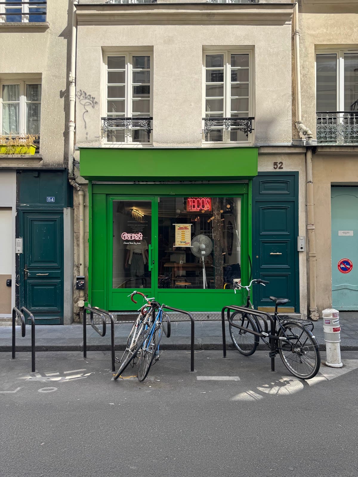 Exterior of building with green facade and bicycles at front in Paris