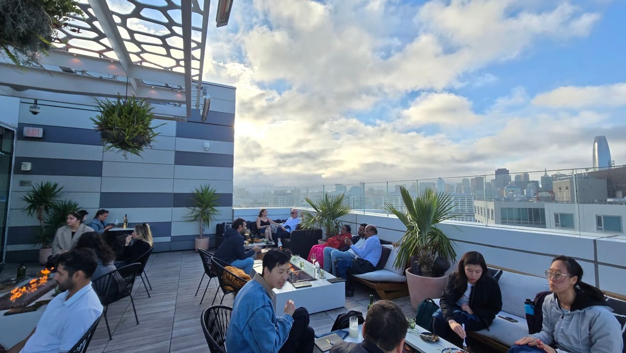 Rooftop bar with people enjoying drinks and city skyline view in San Francisco