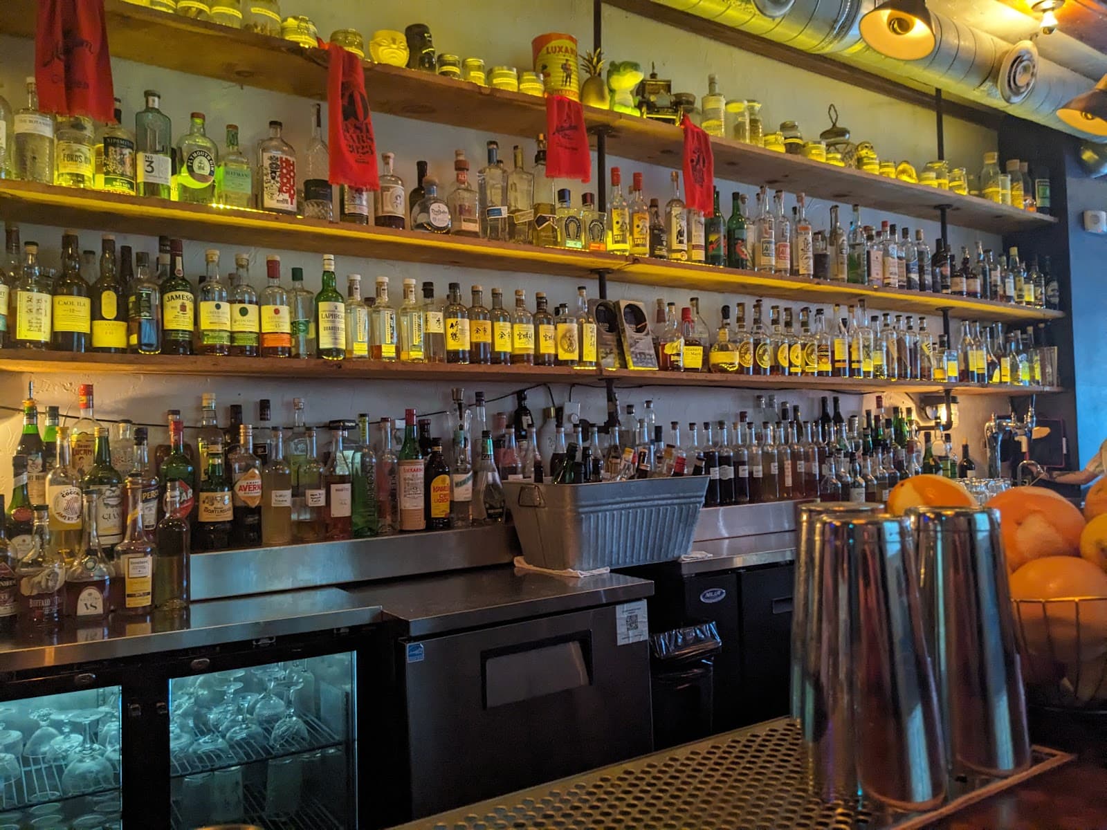 Well-stocked bar shelf with bottles and dim lighting