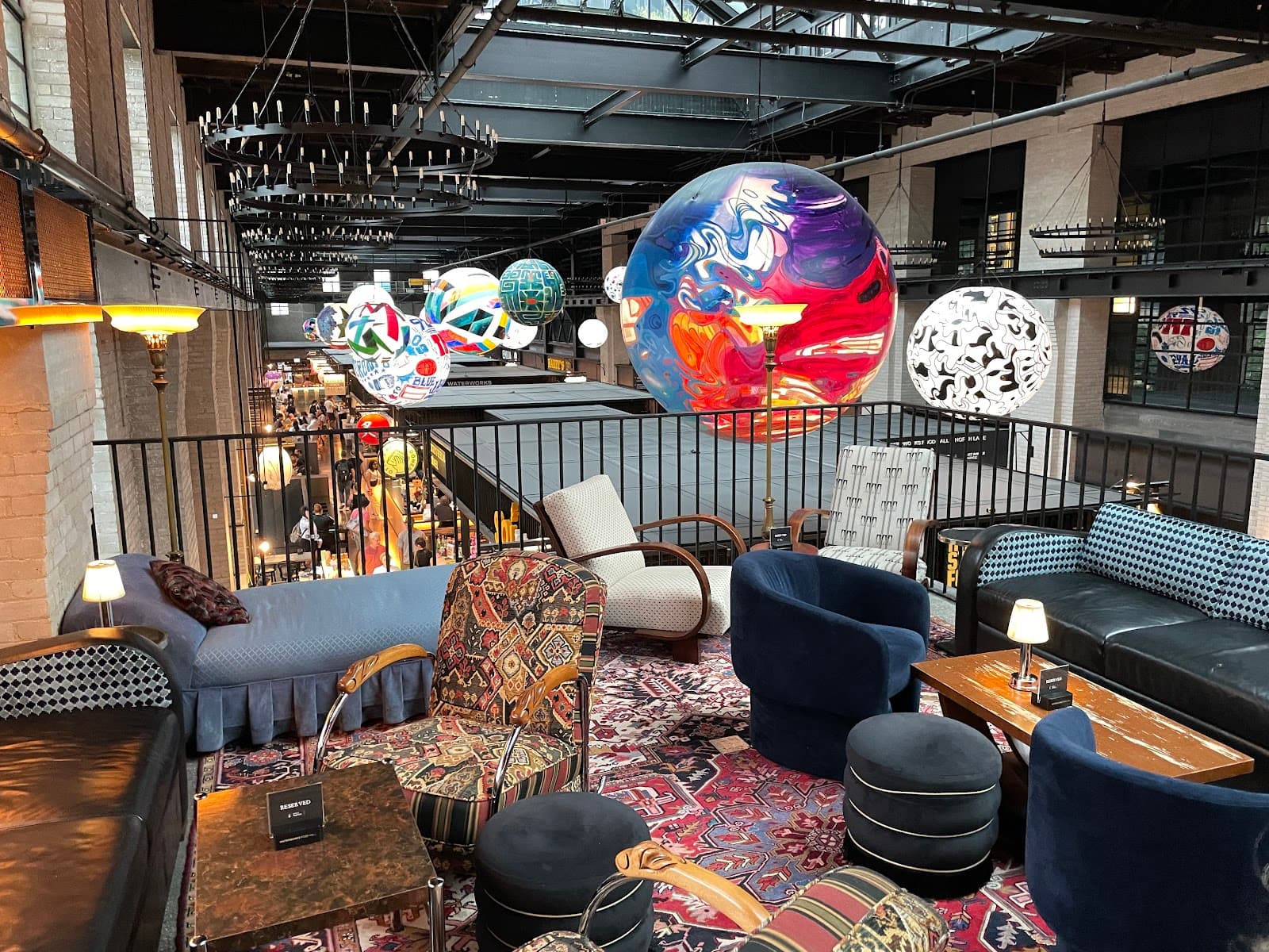 Cozy cocktail bar interior with colorful hanging art and plush seating in Toronto