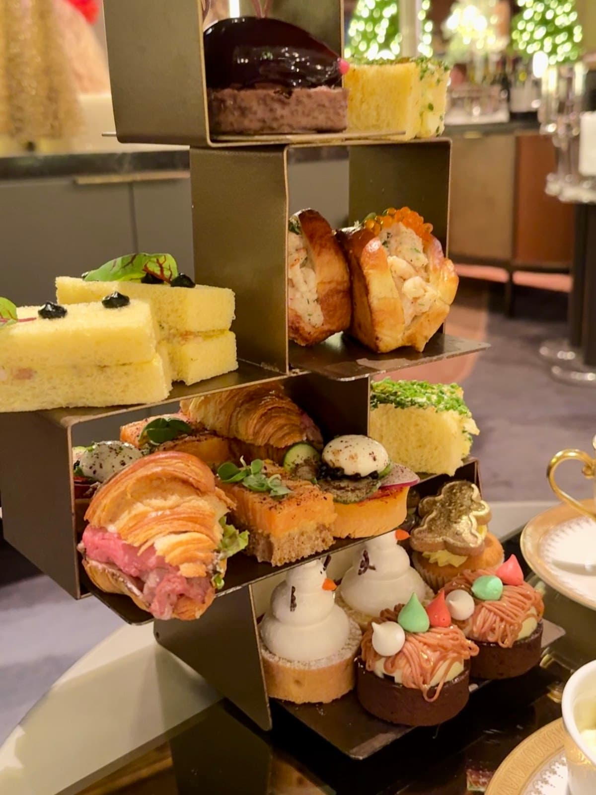 Assorted pastries on a tiered stand with blurred festive background in Toronto